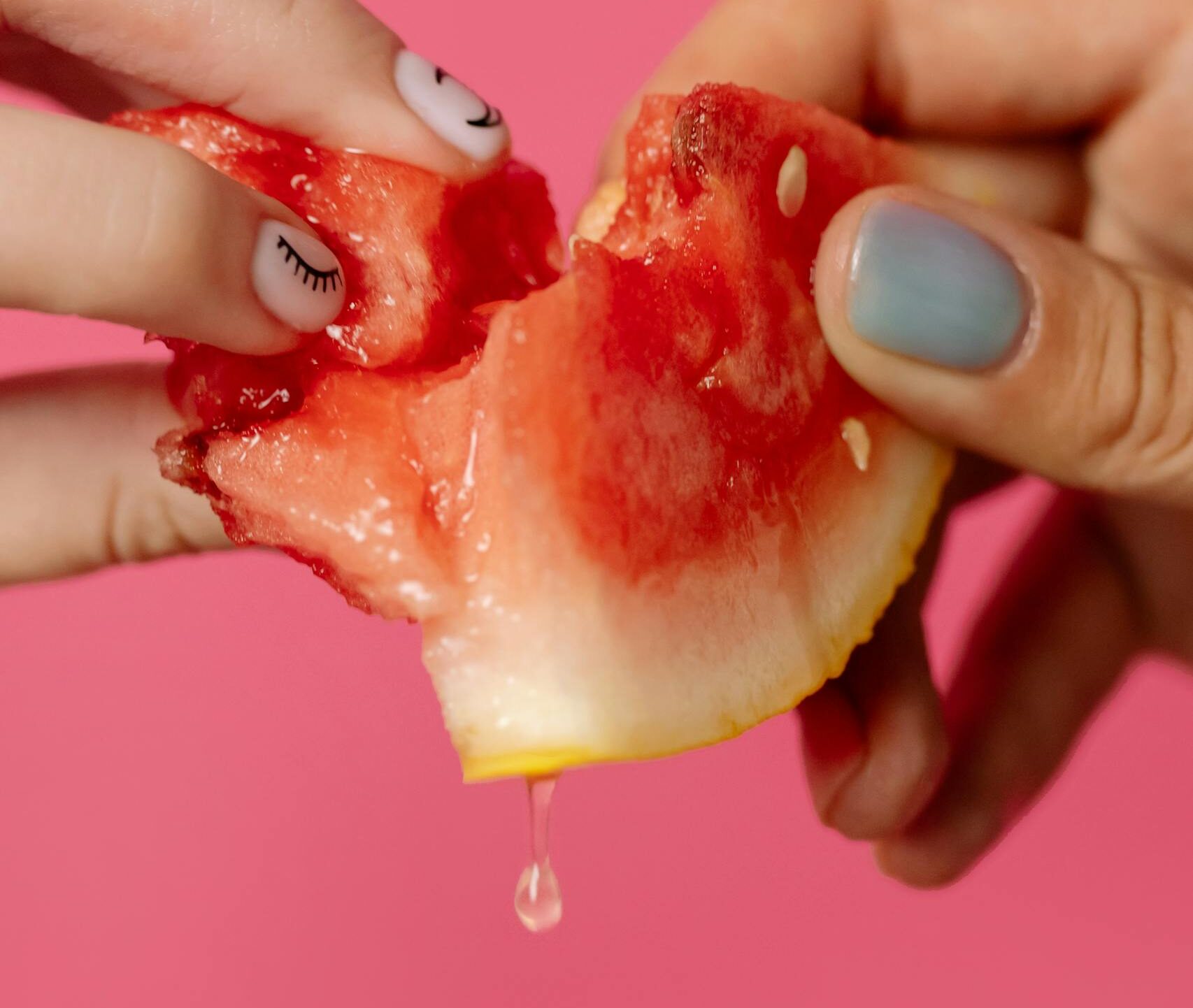 Person Breaking a Slice of Watermelon